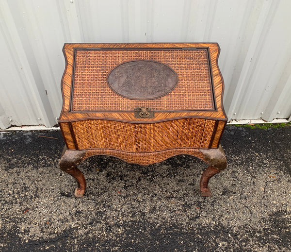 Wrapped wicker with cabriolet legs treasure chest with carved metal palm plaque.